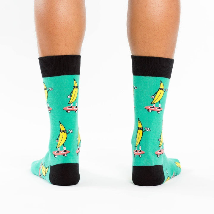 Back view of green crew socks with skateboarding bananas worn on a person&