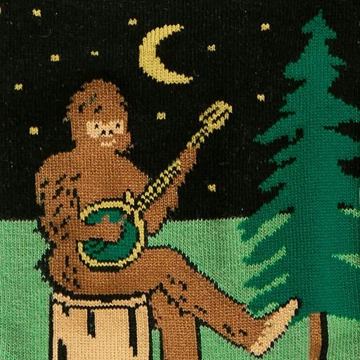 Close-up of a Sasquatch playing a banjo by moonlight knit into the green and black sock