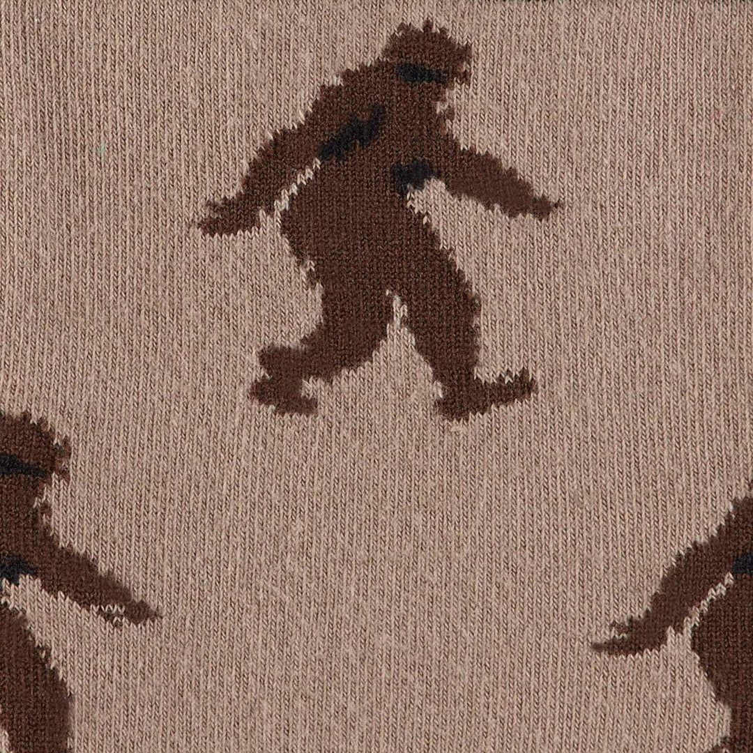 Close-up of a Bigfoot silhouette mid-stride on tan fabric