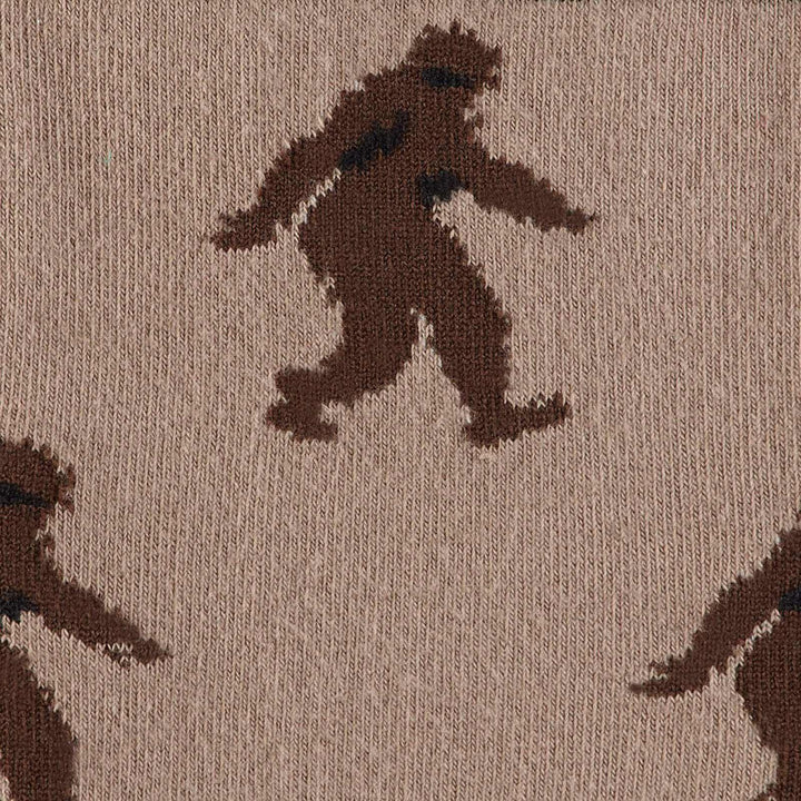 Close-up of a Bigfoot silhouette mid-stride on tan fabric