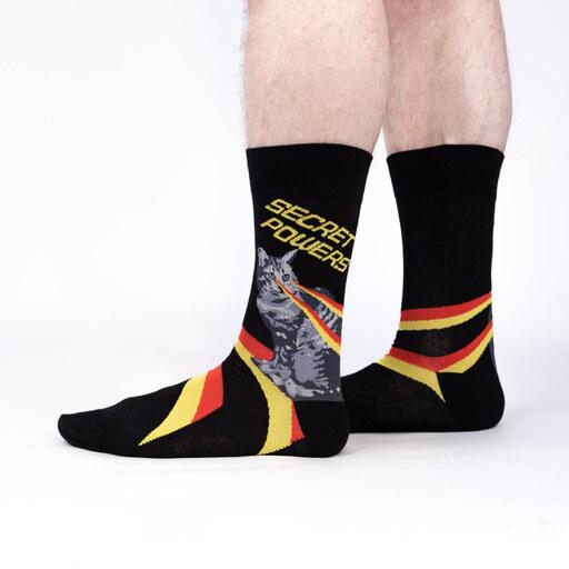 Secret Powers cat socks worn on a model's legs, showing the laser-eyed tabby and energy bolts down to the toe