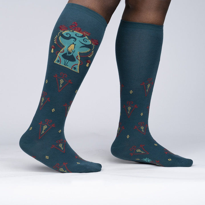 Side view of the Alice knee-highs worn on legs, showing the framed Alice panel and key-and-diamond pattern