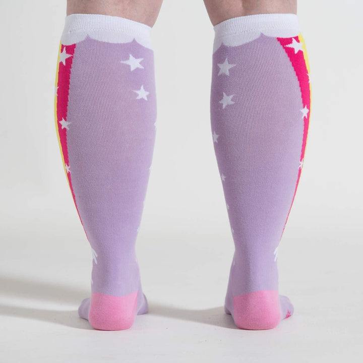 Model wearing lavender unicorn rainbow knee high socks, back view