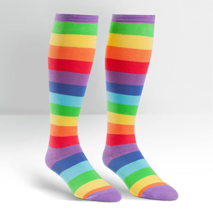 Pair of knee high socks with bold horizontal rainbow stripes and purple cuff and toe