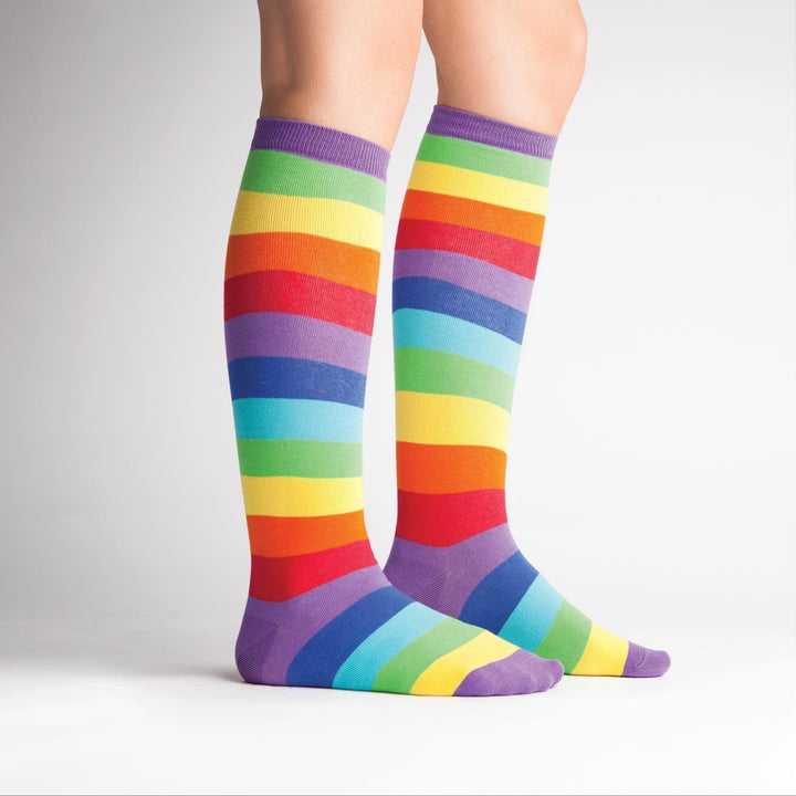 Model wearing rainbow striped knee high socks, side view