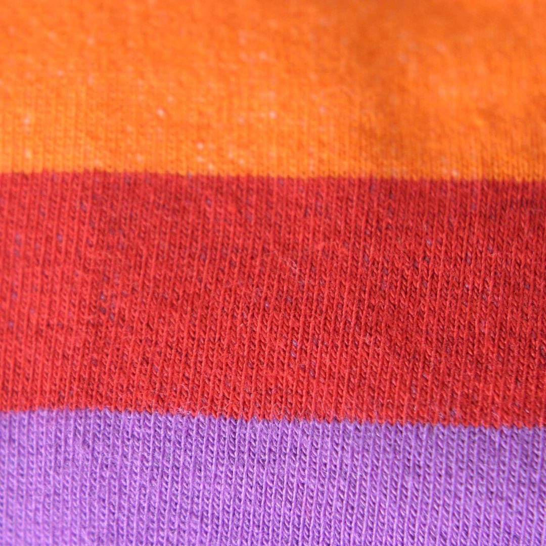 Close-up of orange, red, and purple stripes on a rainbow sock