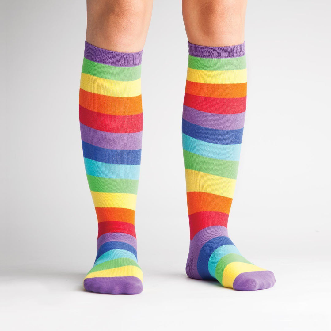 Model wearing rainbow striped knee high socks, front view
