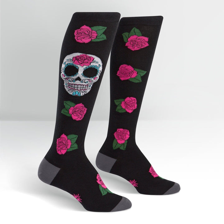Pair of black knee high socks with a colorful sugar skull and pink roses, gray heel and toe