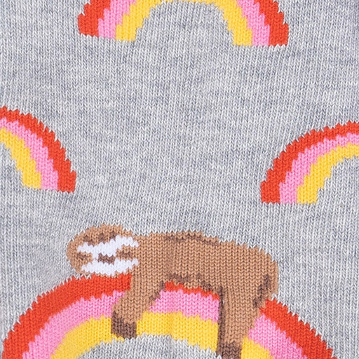 Close-up of the knit design: orange, pink, and yellow rainbows with a brown sloth draped over one rainbow on grey