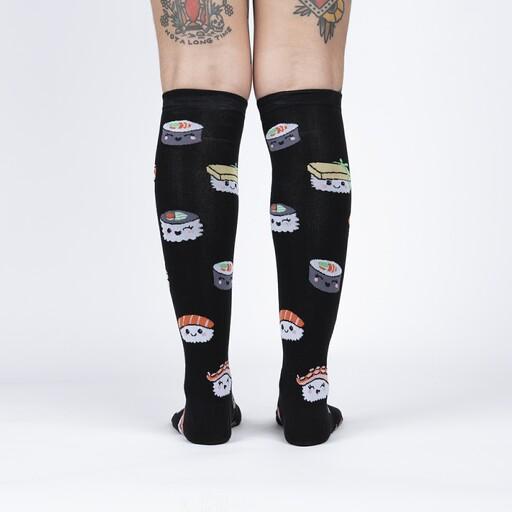 Back view of the sushi knee high socks worn, showing smiling sushi pieces across the black socks
