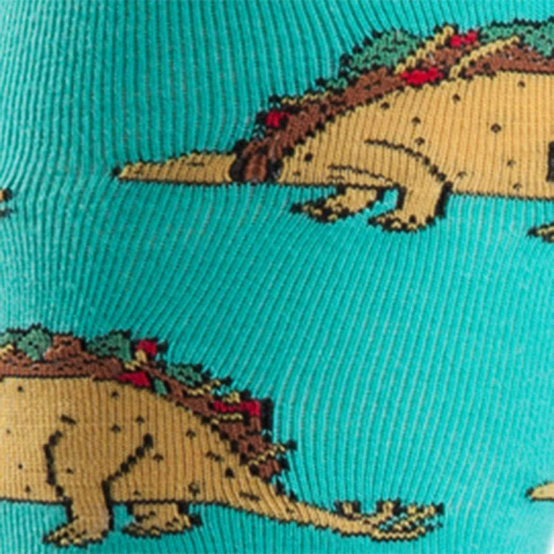 Close-up of taco-shelled dinosaurs with lettuce and meat on a turquoise sock
