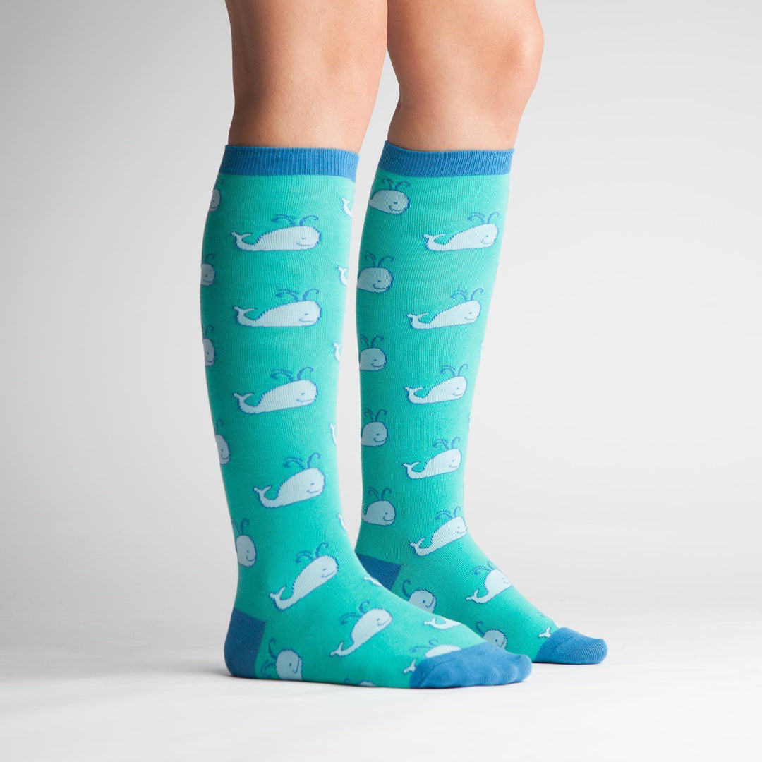 Side view of teal whale knee high socks on a model