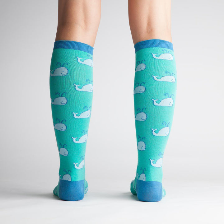 Back view of teal whale knee high socks on a model