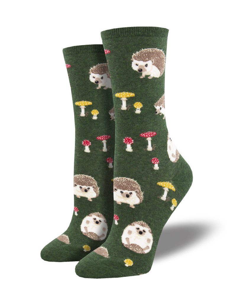 Women's green crew socks on foot forms, patterned with adorable hedgehogs and red-and-yellow mushrooms
