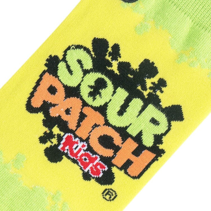 Close-up of the green and orange Sour Patch Kids logo knit on yellow background