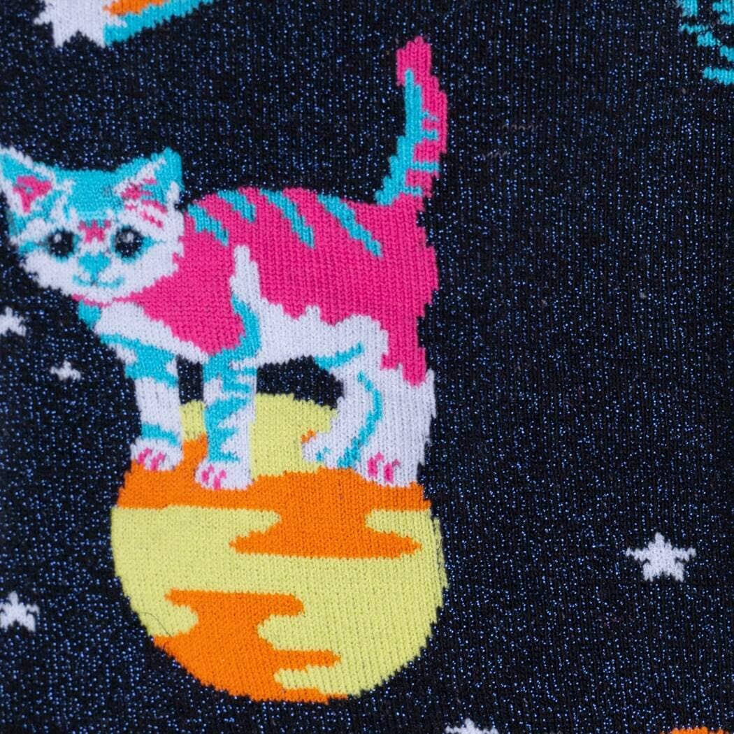 Close-up of a pink-and-white striped cat standing on a yellow planet against a starry sky