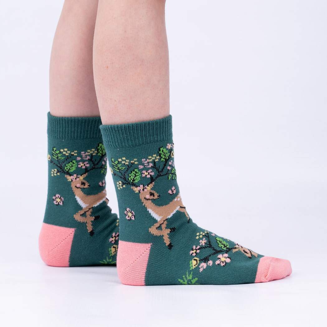 Side view of child wearing the green deer-with-blossom-antlers crew socks