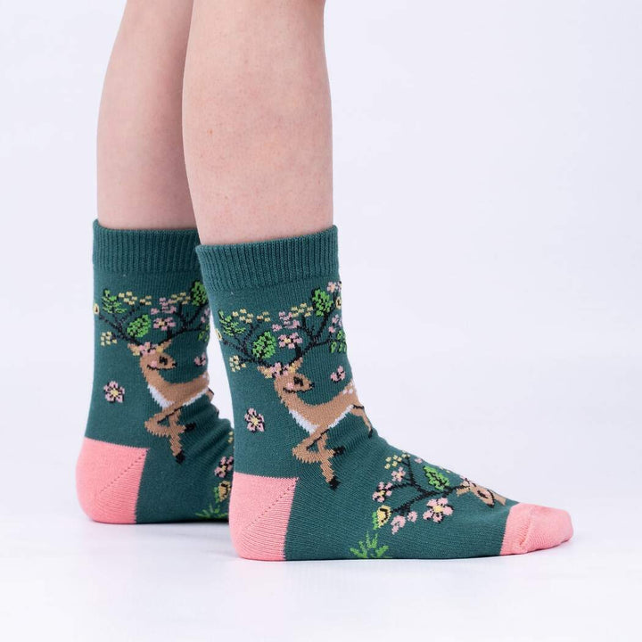Side view of child wearing the green deer-with-blossom-antlers crew socks
