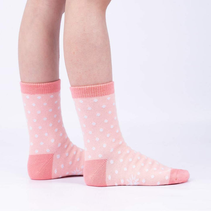 Side view of child wearing the pink polka-dot crew socks with coral heels and toes
