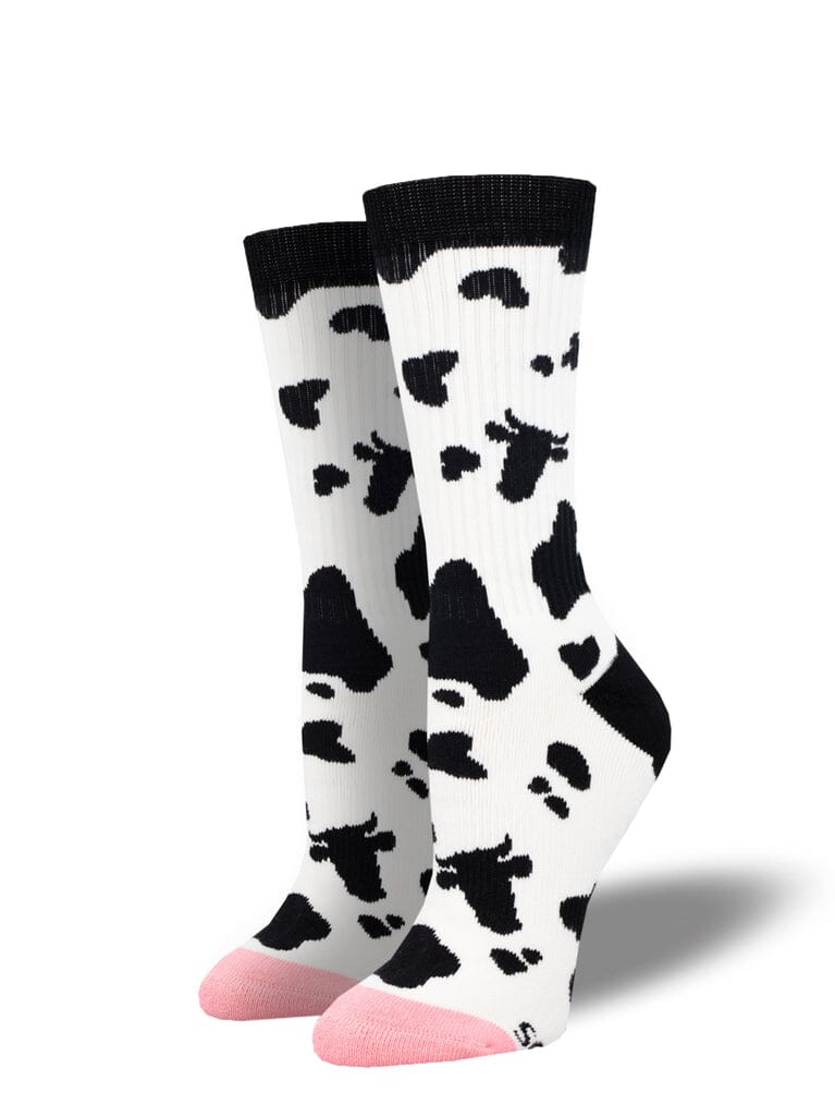 Women's steer hide athletic crew socks, flat lay showing black cow-print spots on white with pink heel and toe