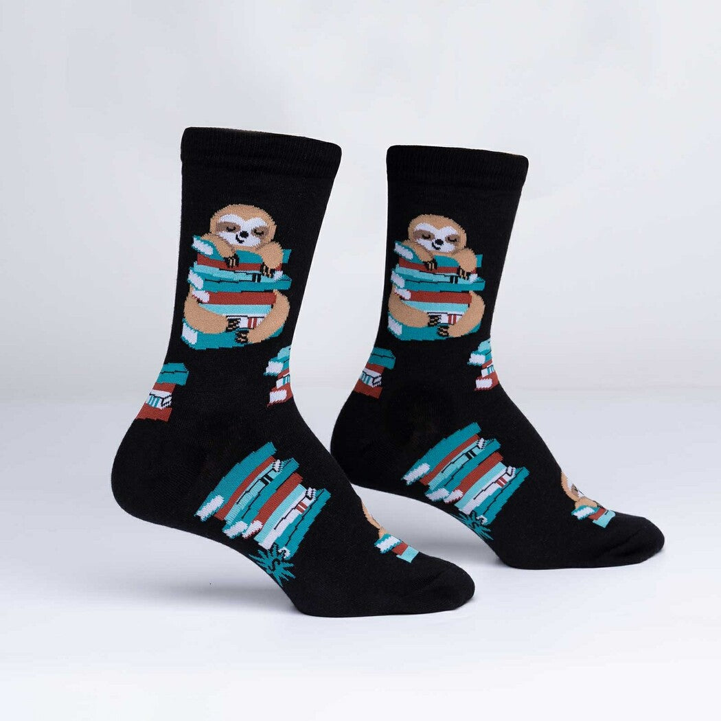 Pair of black crew socks with a sloth hugging a stack of colorful books, display view