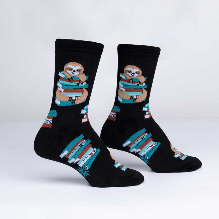 Pair of black crew socks with a sloth hugging a stack of colorful books, display view