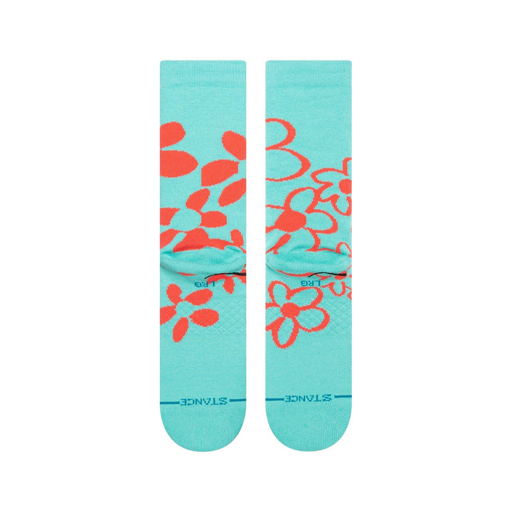 Reverse view of the turquoise socks showing scattered coral flower outlines and STANCE lettering