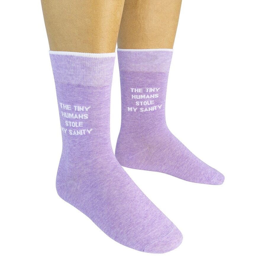 Pair of heather-purple "Tiny Humans Stole My Sanity" crew socks worn on a person's feet, front view