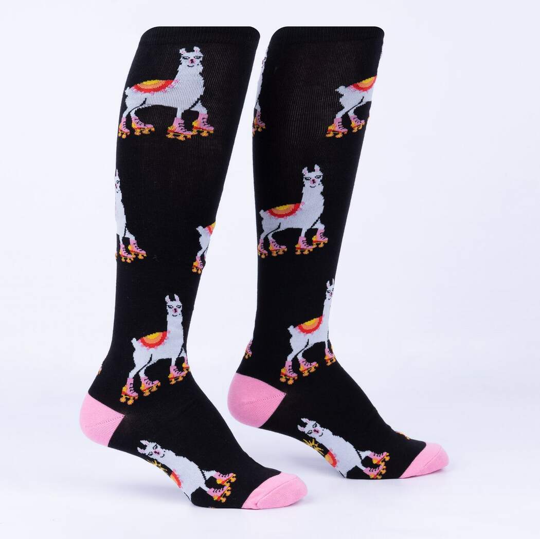 Flat-lay of black women's knee high socks with white roller-skating llamas in rainbow blankets and hot-pink heels and toes
