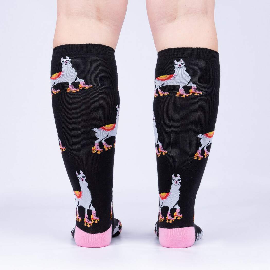 Back view of model wearing the roller-skating llama knee high socks showing llamas on skates up the calf