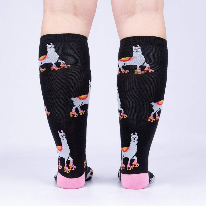 Back view of model wearing the roller-skating llama knee high socks showing llamas on skates up the calf
