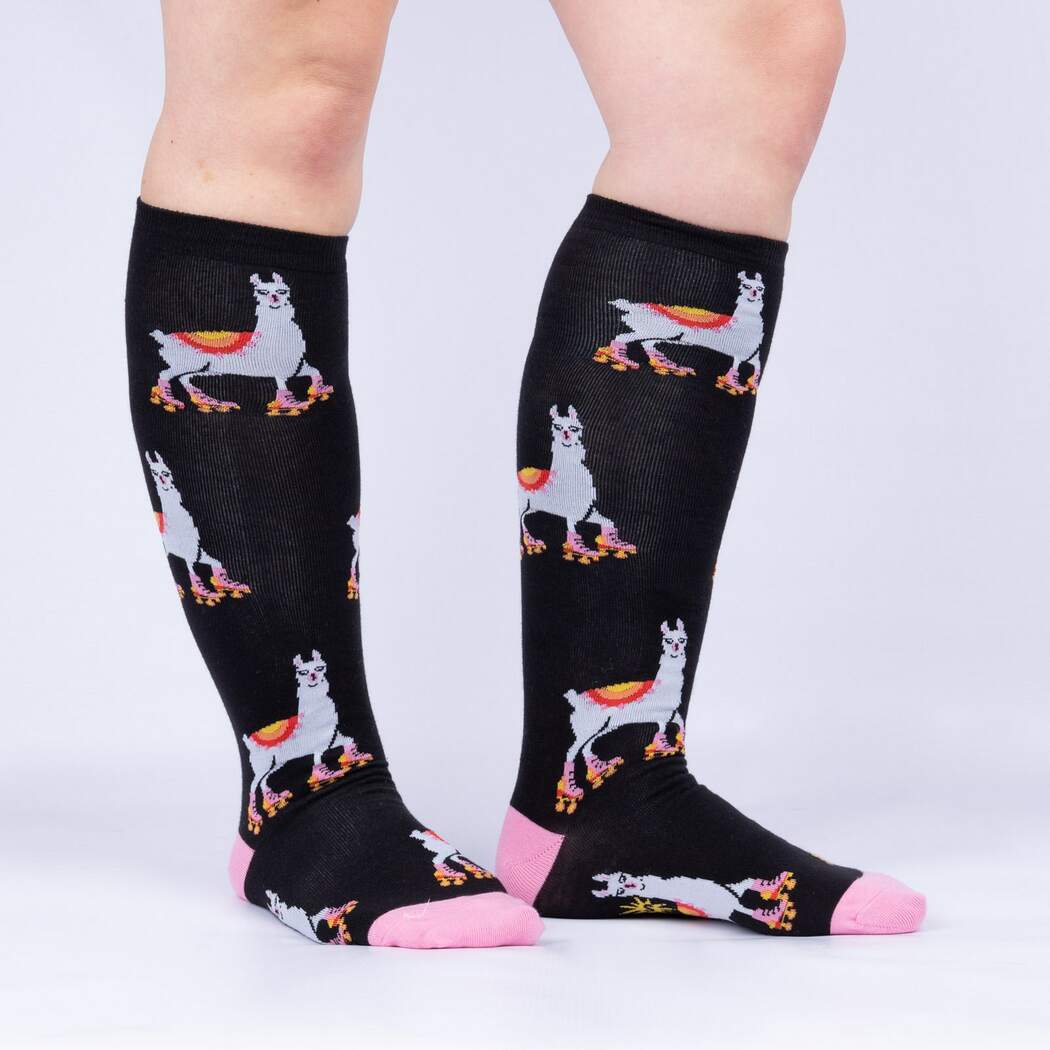 Side view of model wearing the black roller-skating llama knee high socks with pink toes