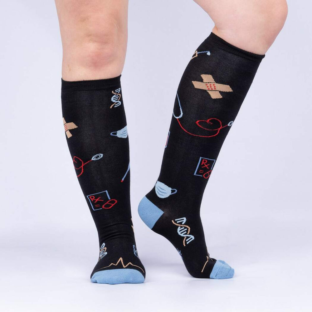 Side view of model wearing the black medical-themed Thoracic Park knee high socks